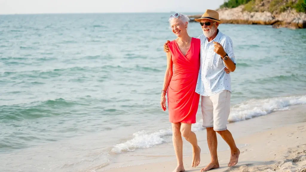 iKare - senior couple walking on the beach